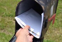 Hand retrieving mail from an open rural mailbox