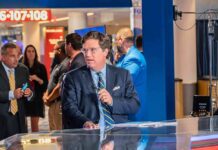 Media Civil War Erupts on Antisemitism News anchor in suit at a studio desk