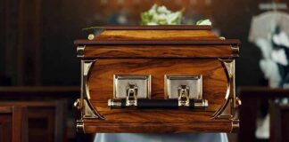 wooden coffin with brass handles in a church