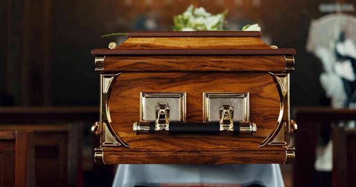 wooden coffin with brass handles in a church