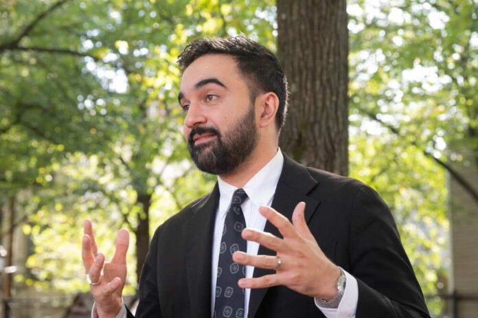 Man in a suit gesturing while speaking outdoors