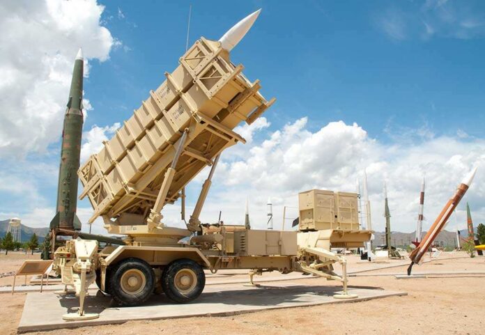 Patriot Patriot missile defense system on display outdoors with various missiles in the background