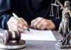Appeals Court Nukes DOJ Power Play Judge writing at desk with gavel and Lady Justice statue