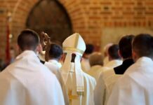 Archbishop Slams Eucharist Stunt Bishop in white mitre among clergy during church procession