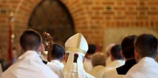 Bishop in white mitre among clergy during church procession
