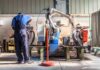 Royal Navy’s Costly Ghost Ship Factory worker operates near an industrial robot arm in a workshop