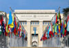 United Nations building with numerous national flags outside.