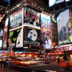 Vibrant night scene of Times Square filled with theater advertisements and neon lights