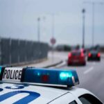 Police car with blue lights on near a roadway