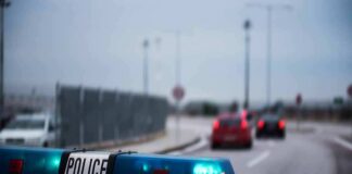 Police car with blue lights on near a roadway