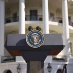 Presidential podium with seal in front of white-columned building