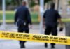Domestic Homicide Shock in Illinois Police officers walking past caution tape at a crime scene