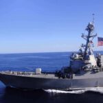 Blockade Bombshell: 100 Ships Rerouted Naval destroyer sailing on open sea with flag flying