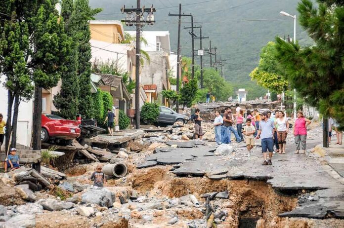 shutterstock_1165722466 Residents walk along a heavily damaged street after a disaster