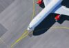 Airplane taxiing on airport tarmac from above