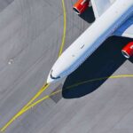 Airplane taxiing on airport tarmac from above
