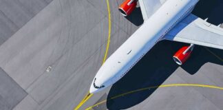 Airplane taxiing on airport tarmac from above