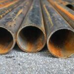 Rusty metal pipes laid on gravel