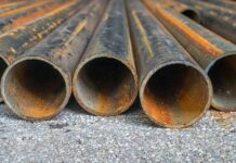 Trump’s $15B Steel Plant Gamble Shakes Iowa Rusty metal pipes laid on gravel