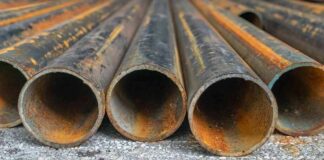 Rusty metal pipes laid on gravel