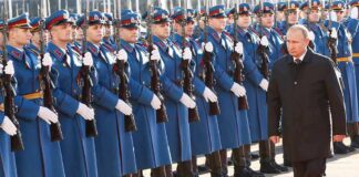 Vladimir Putin walks past an honor guard; Genaro García Luna and Darius Kilgo not visible