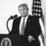 Viral Lion Montage Sparks Instant Backlash Donald Trump at a podium with microphone and U.S. flag in background