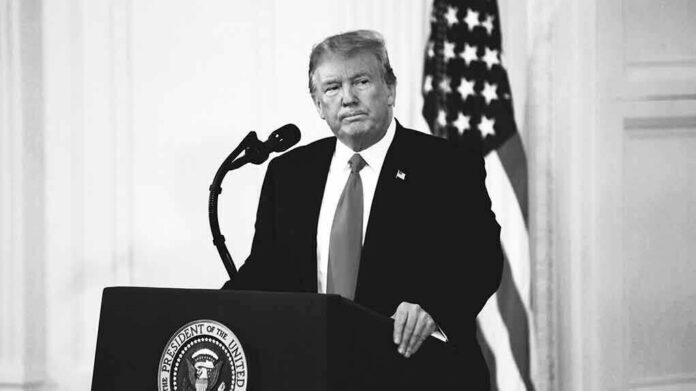 Donald Trump at a podium with microphone and U.S. flag in background