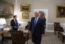 Donald Trump walks through an office with Sean Lawler nearby and Mariano Rajoy following behind