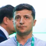 man with short dark hair wearing a lanyard
