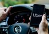 Driver holding smartphone with Uber app inside Volkswagen
