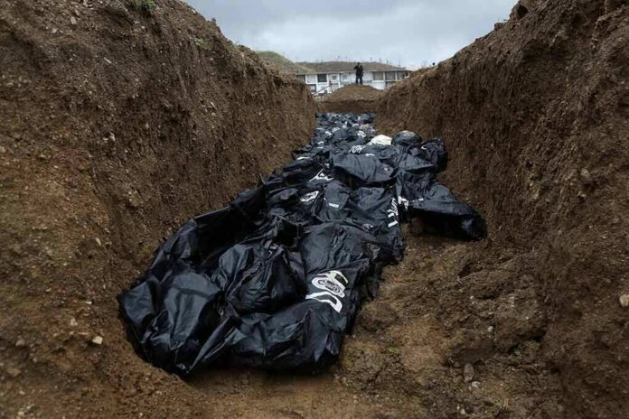 shutterstock_1614227278 Body bags in a mass grave trench