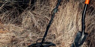 Metal detector and shovel in dry grass