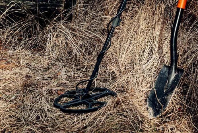 shutterstock_1627880485 Metal detector and shovel in dry grass