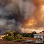 Wildfire smoke billows over suburban houses