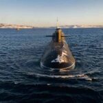 Submarine cruising on cold open water toward camera