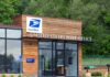 Gun Ban Whiplash Stuns Mail Lines Exterior view of a modern United States Post Office building surrounded by greenery
