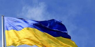 Ukrainian flag waving on a flagpole against blue sky