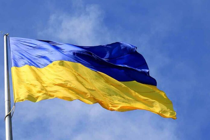 shutterstock_2128824860 Ukrainian flag waving on a flagpole against blue sky