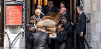 Pallbearers carry a casket down church steps