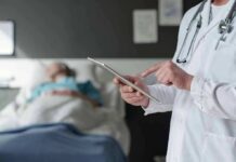 Doctor Fined After Puberty Blocker Refusal Doctor using tablet beside hospital patient