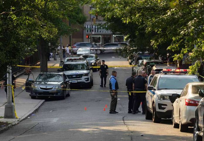 shutterstock_2330301305-2 Police officers secure a residential street with patrol cars and yellow tape