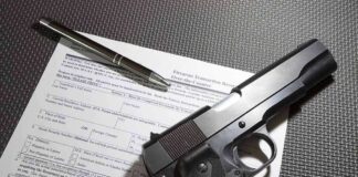 Handgun on firearm transaction form with pen