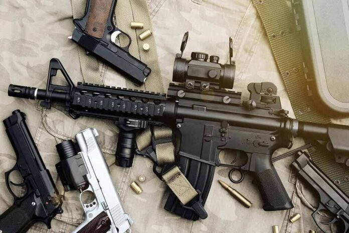 shutterstock_618468797 Assault rifle and handguns on tactical gear