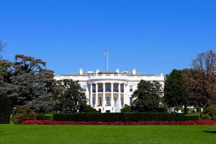 shutterstock_1051409453 The White House facade with flag and gardens