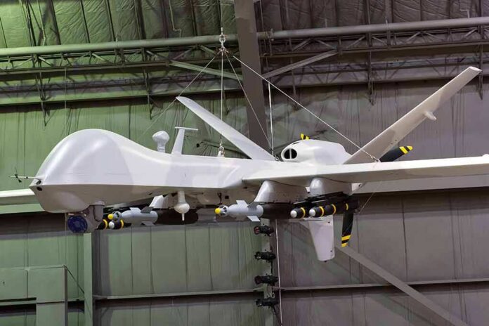 shutterstock_1093736552 military drone with missiles suspended in a hangar
