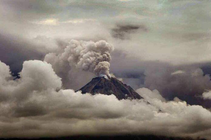shutterstock_1190133376 Volcano erupting with ash plume above cloud layer