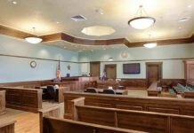 Courtroom Banter Sparks Bias Uproar Empty courtroom with wooden benches and judge's bench