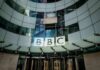 BBC Closes Three Broadcast Channels Amid £500 Million Cuts BBC headquarters entrance with curved glass facade