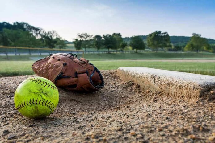 shutterstock_1411597688 Softball and glove near a base on a dirt field