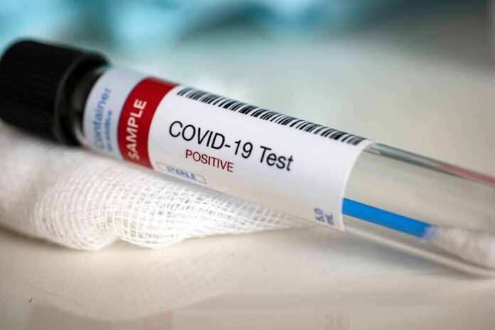 shutterstock_1673330692 COVID-19 test tube labeled positive on gauze